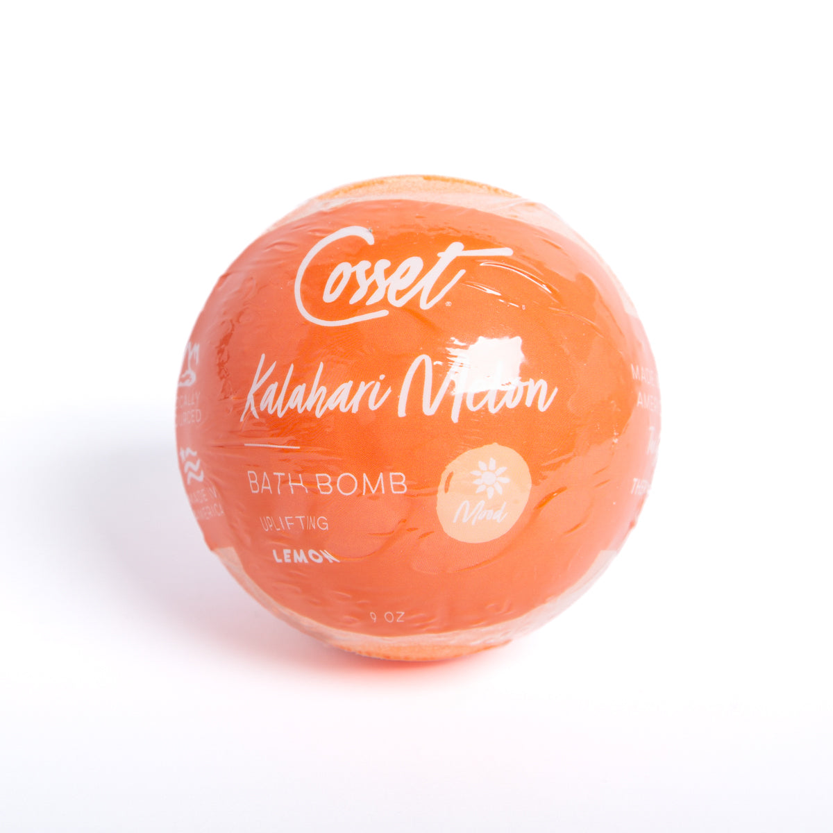 Round, 9 oz orange Kalahari Melon bath bomb wrapped in clear plastic with white text and lemon scent branding.